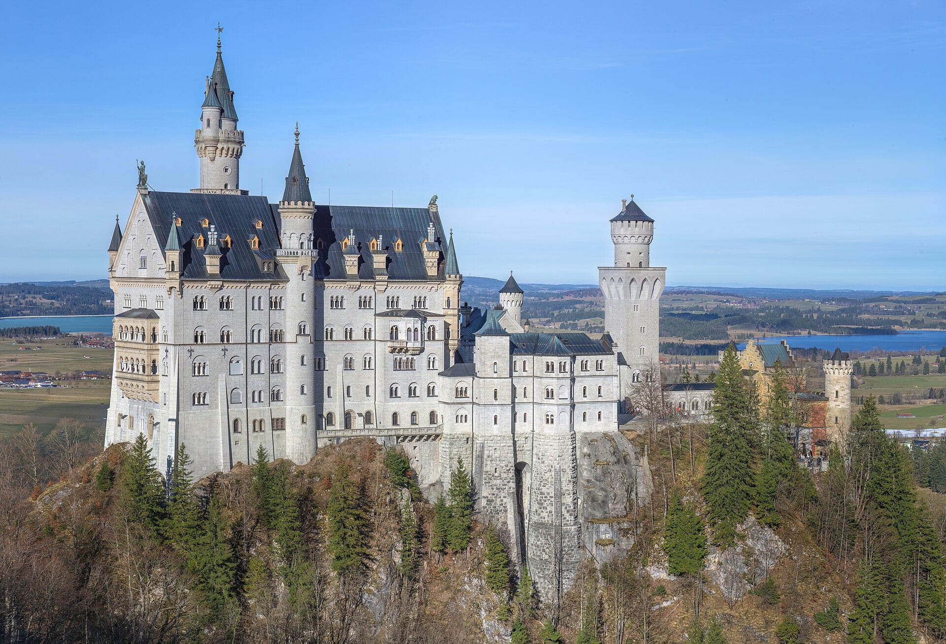 Neuschwanstein Castle above the forested Bavarian foothills, Germany.